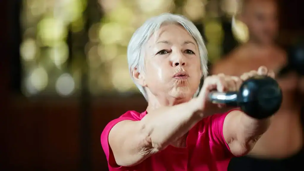 Older woman doing weight training Horley to help her strength and longevity 