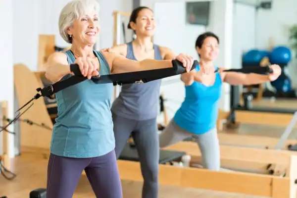 Toning Arms After 60: Empowering Womens Fitness Through Effective Weight Training 2 older woman doing weight training Horley and resistance in the gym to tone upper arms
