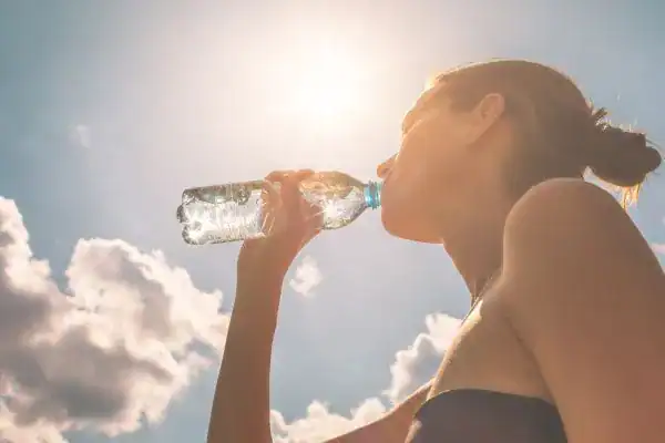 Hydration: The Secret Ingredient for a Toned Stomach and Enhanced Fitness 3 Image of woman drinking water to hydrate Horley after run.
